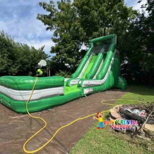 Large green water slide inflatable rental set up for an event in Columbus, Indiana, great for birthdays, school events, and family celebrations.