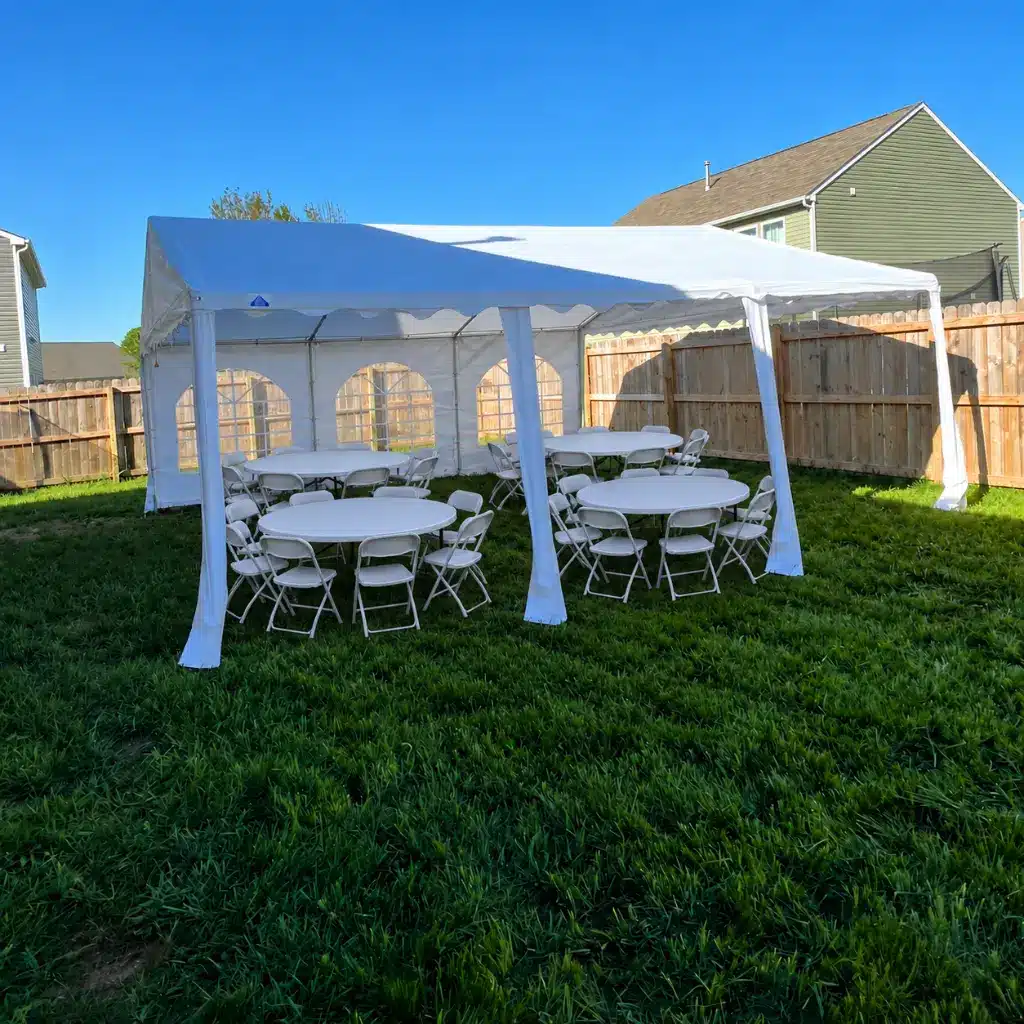 White 20x20 event tent with round folding tables and chairs set up for a family celebration or graduation party in Columbus, IN